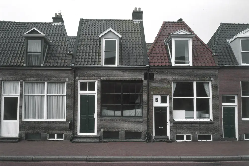 Rij bakstenen woningen met dakkapellen aan de voorzijde van het dak, passend bij de buren